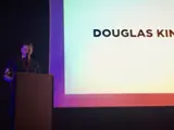 Douglas King on stage at a podium